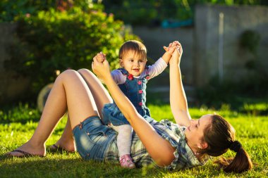 Anne ve kızı güneşli bahçede eğleniyor