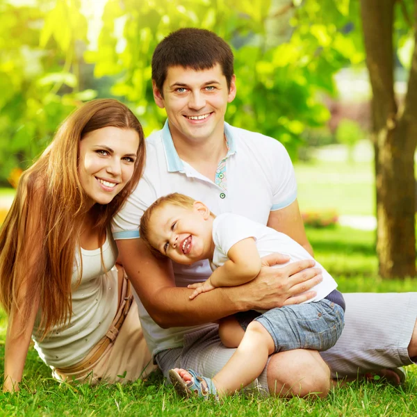 Ung familj ha kul i sommar park — Stockfoto