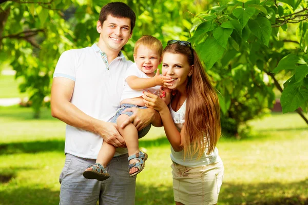 Молодая семья веселится в летнем парке — стоковое фото