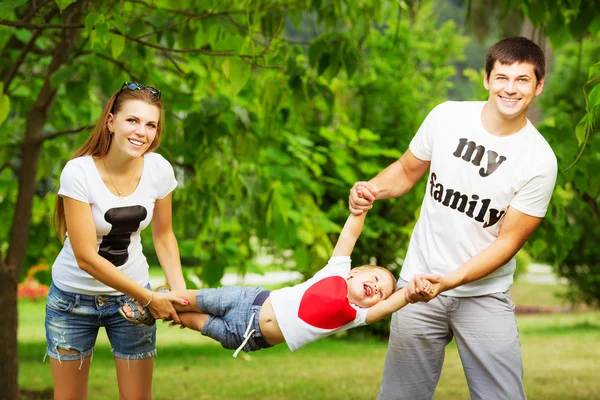 Νεαρή οικογένεια διασκεδάζοντας στο πάρκο καλοκαίρι — Φωτογραφία Αρχείου
