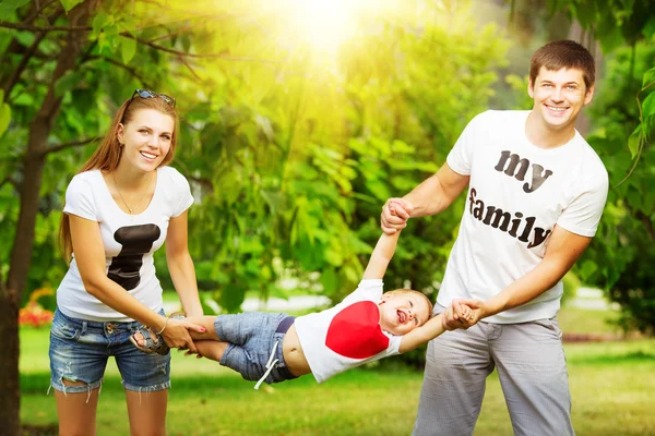 Ung familj ha kul i sommar park — Stockfoto