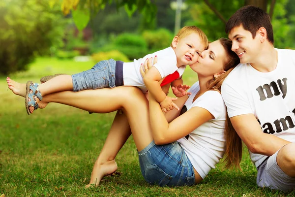 Familia joven divirtiéndose en el parque de verano — Foto de Stock