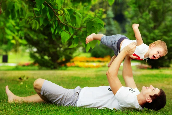 Vader en zoon plezier in zomer park — Stockfoto