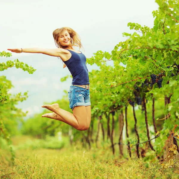 Счастливая женщина прыгает в виноградник — стоковое фото