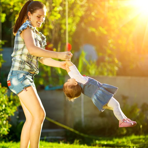 Moeder en dochter plezier in zonnige tuin — Stockfoto