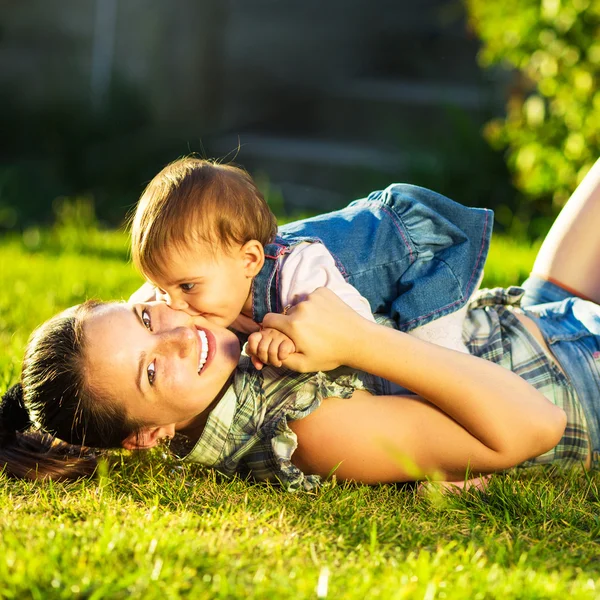 Madre e hija divirtiéndose en un jardín soleado — Foto de Stock