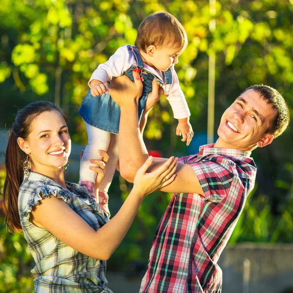 Feliz jovem família se divertindo ao ar livre — Fotografia de Stock