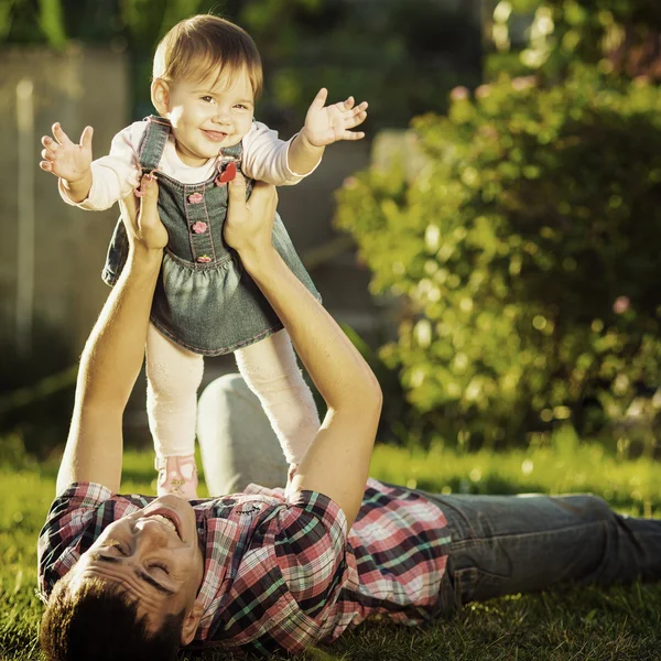 父亲和宝贝女儿开心在阳光充足的花园. — 图库照片