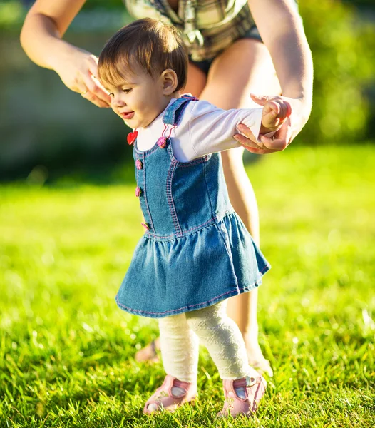 Babymeisje doet haar eerste stappen met moeders hulp — Stockfoto
