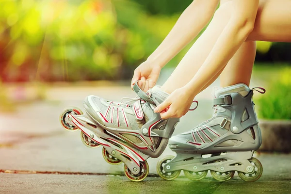 Vrouw zetten inlineskates — Stockfoto