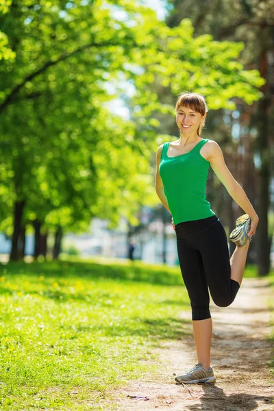 Mulher se exercitando no parque ensolarado — Fotografia de Stock