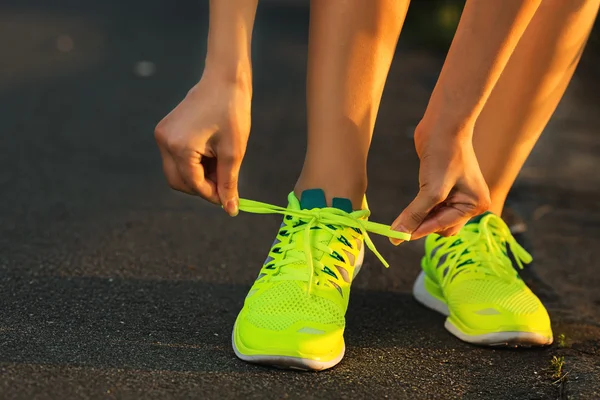 Vrouw koppelverkoop veters op loopschoenen — Stockfoto