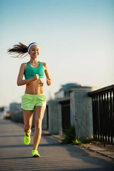 Woman running in city on quay — Stock Photo, Image