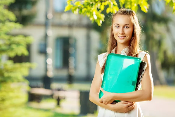 Studentské žena s složku a kopírování knihy — Stock fotografie