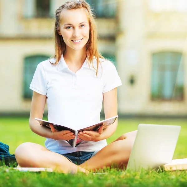 学生女人坐在草坪上 — 图库照片