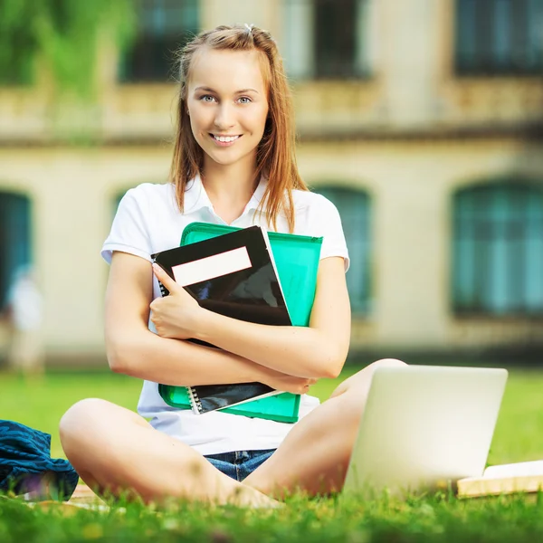 芝生の上に座っている学生女性 — ストック写真