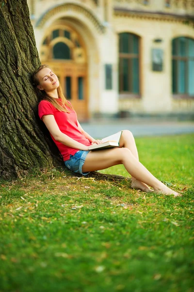 Student kobieta marzy w pobliżu drzewa z książki — Zdjęcie stockowe