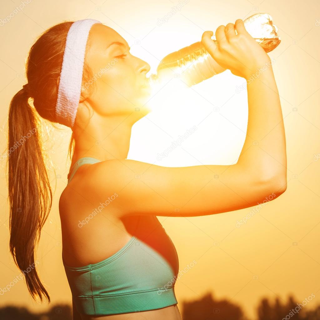 Woman drinking water after running