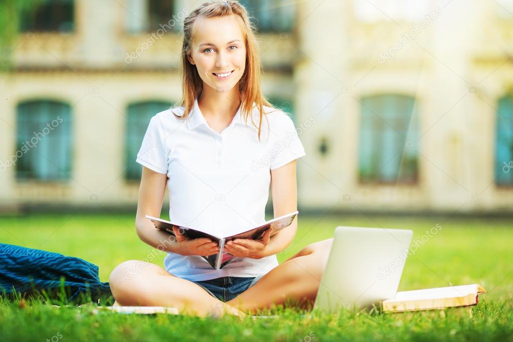 Student woman sitting on lawn