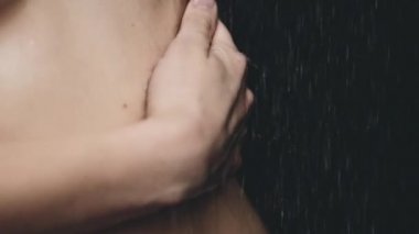 dökülen suyun altında duran kadın