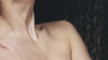 dökülen suyun altında duran kadın