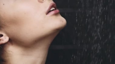 dökülen suyun altında duran kadın