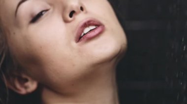 dökülen suyun altında duran kadın