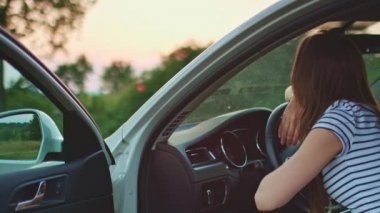 woman resting on car wheel
