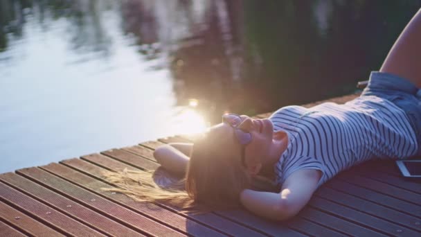 Femme relaxant sur jetée en bois 