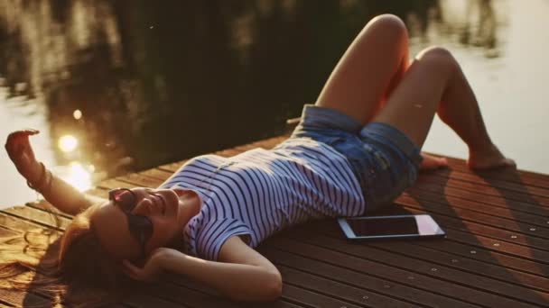 Femme relaxant sur jetée en bois 