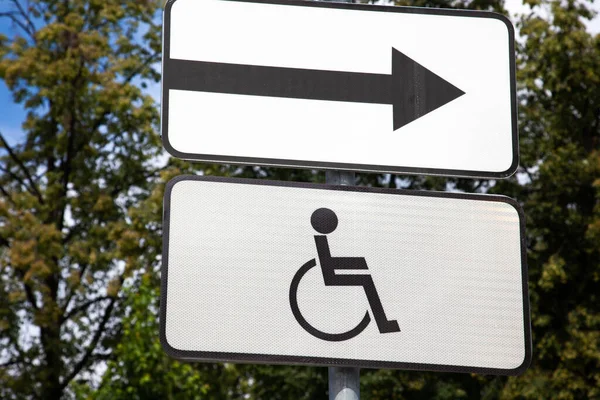 Otoparkta tekerlekli sandalyenin siyah engelli sembolü engelli ziyaretçiler için park yeri işareti.
