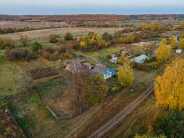 Sonbaharda bir Rus köyünün üzerinde uçuyor.
