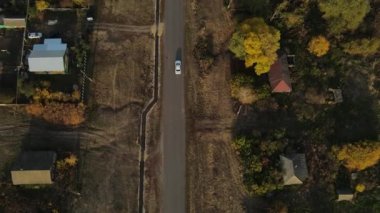 Rusya 'nın güzel sonbahar köyünden araba geçiyor.