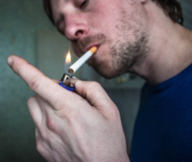 Traşsız bir adam sigara yakıyor. Yüksek kalite fotoğraf