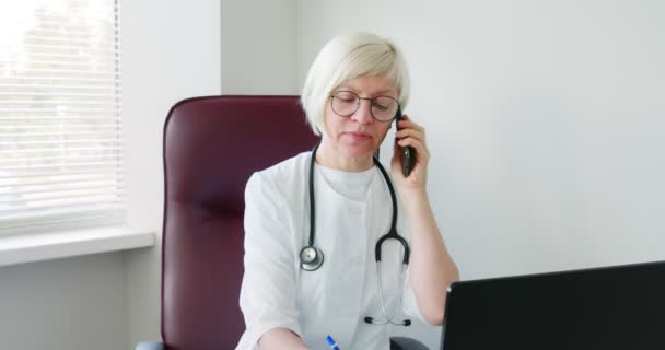 Doctora Consultando Paciente Usando Llamadas Telefónicas Escuchando Hablando Síntomas Anotando — Vídeos de Stock