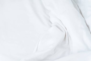Beyaz buruşuk çarşaf dalgalı maket. Sabah yatağı. Kumaş kumaş dokusu. Beyaz minimalist arkaplan.