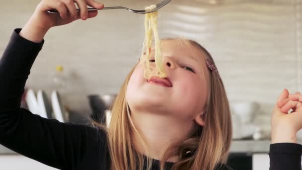 台所でスパゲティパスタを食べている子供の少女の肖像画 かわいい就学前の子供はビーガン食麺を食べる — ストック動画