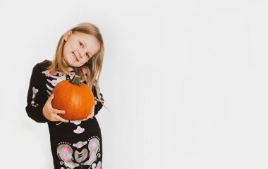 Cadılar Bayramı kostümü giymiş bir çocuk elinde büyük bir balkabağı tutuyor ve boş fotokopi aletiyle beyaz arka planda gülümsüyor..