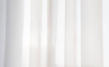 Açık bir pencereden şeffaf beyaz perde tülü. 