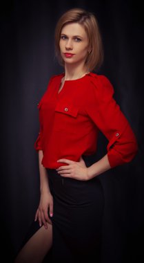 güzel genç kız siyah bir arka plan üzerinde duruyor