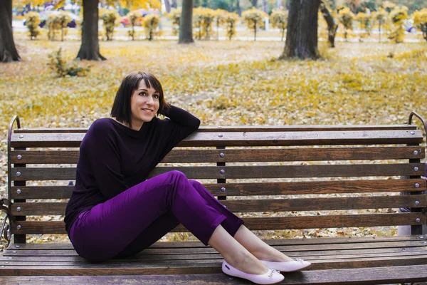 Young beautiful girl sitting on a bench — Stock Photo, Image