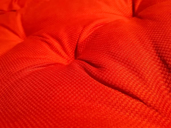 Red soft wrinkled cloth of the cushion or sofa as background