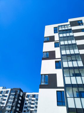 Mavi gökyüzünün karşısındaki modern apartmanın bir parçası.