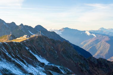 Karlı yüksek dağın tepesinde ve gökyüzünde bulutlar - güneşli bir gün