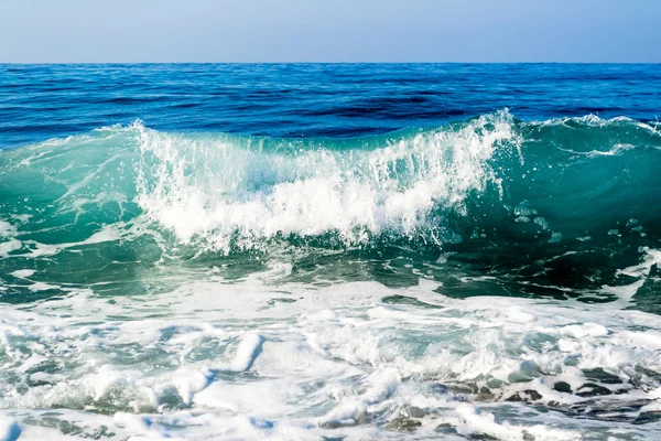 Vågor på en stenig strand, bildar sprayer — Stockfoto