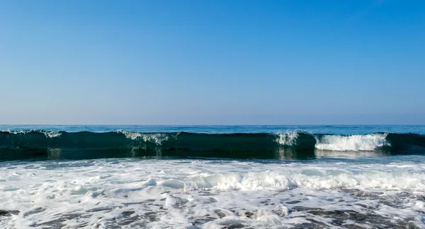 Vågor på en stenig strand, bildar sprayer — Stockfoto