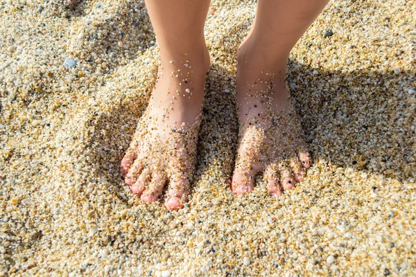 Pies de un niño en la arena — Foto de Stock