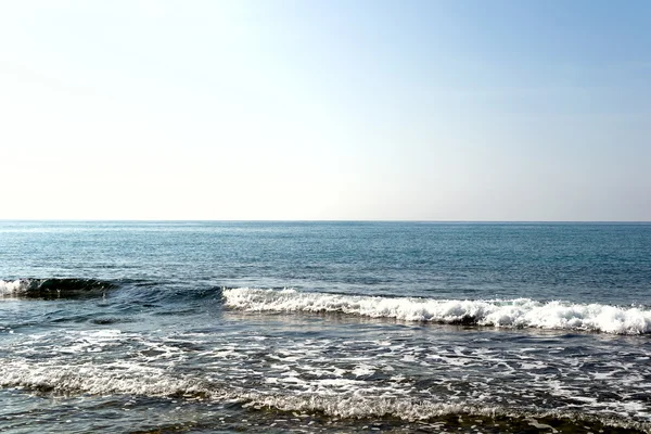 Vagues se brisant sur la plage pierreuse solitaire, formant des sprays — Photo