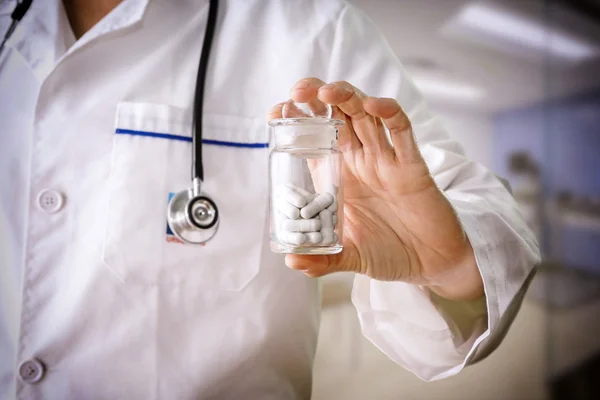 Close-up do médico segurando um recipiente pílula — Fotografia de Stock