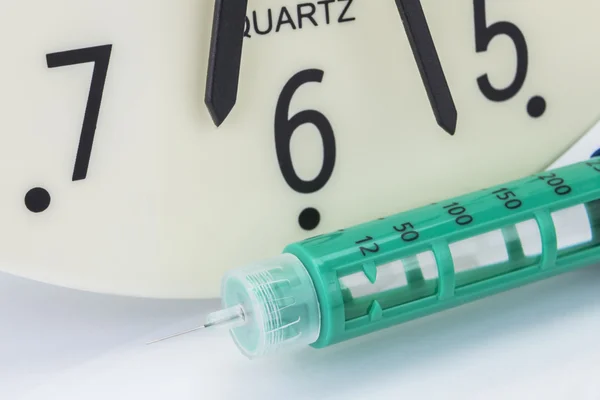 Jeringa de insulina, el reloj muestra la hora del medicamento — Foto de Stock